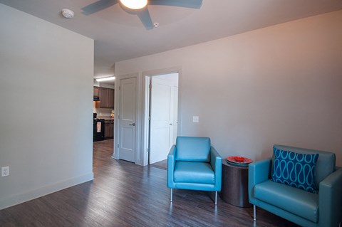 a living room with two blue chairs and a table